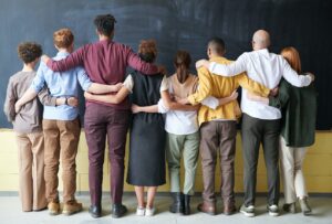 Team of people facing wall with arms around shoulders